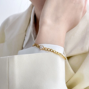 18K gold plated titanium cuban link bracelet featuring a pear cut zircon on model