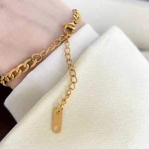 Close-up of gold plated stainless steel curb chain bracelet with lobster clasp detail