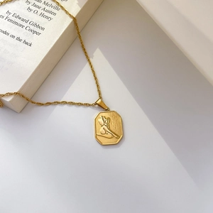 Detail of vintage gold necklace with octagonal pendant featuring female silhouette relief