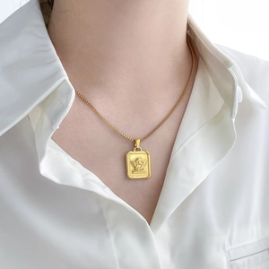 Golden punk style necklace featuring a rectangular angel relief pendant on a box chain