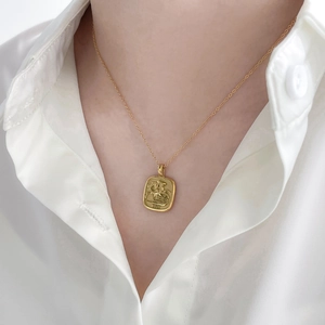 Detail of vintage gold St. George and Dragon pendant necklace with 1932 year engraving
