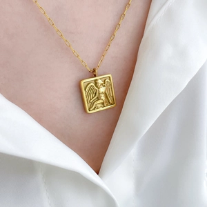 Close-up of gold-plated square angel relief pendant on rectangular link chain