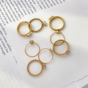 Détails macro de bagues plaquées or 18K avec pierres de zircon et textures perlées