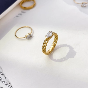 Détail d'une bague chaîne plaquée or 18 carats avec zircon marquise sur papier blanc