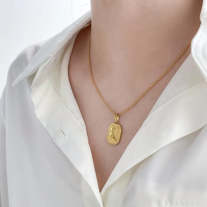 Close-up of gold plated stainless steel octagon pendant necklace on a female model