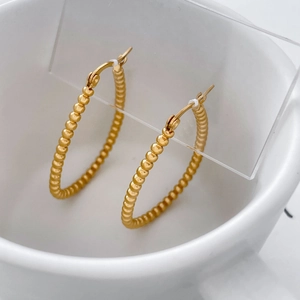Detailed close-up of 18K gold-plated stainless steel hoop earrings with beaded texture