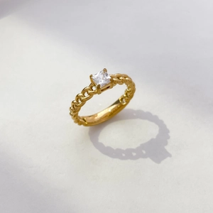 Détail d'une pierre de zircon carrée sur une bague à maillons plaquée or 18 carats