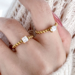 Vue détaillée de bagues perlées en plaqué or avec zircons carrés et ovales sur tricot