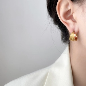 Classic 18K gold plated hoop earrings with vertical shell texture on a model in white suit