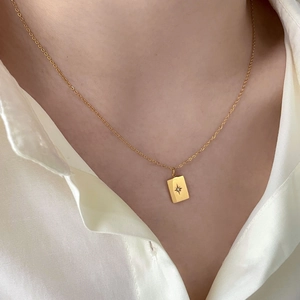 Detail of 18K gold plated rectangular pendant with starburst engraving and crystal