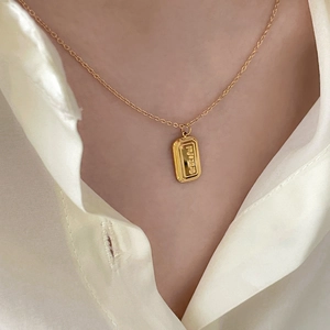 Close-up of golden rectangular pendant engraved with Graceful on a thin cable chain