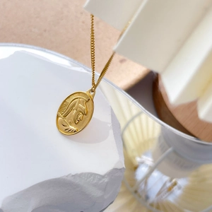Détail macro du collier pendentif ovale doré avec relief classique d'un portrait gravé