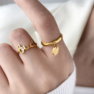 Détail de la bague lettre lucky et bague avec pendentif disque doré minimaliste