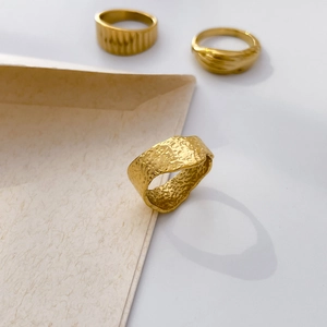 Detailed view of 18K gold plated titanium ring with irregular hammered texture and matte finish