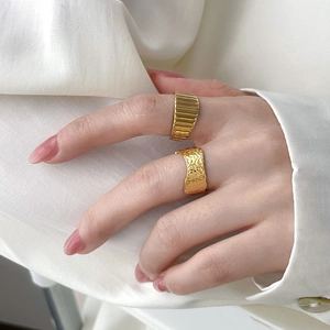 18K gold plated titanium steel rings with ribbed and hammered textures on a silk background