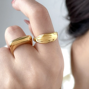 Pair of 18K gold-plated titanium rings with smooth flat face and textured vertical stripes