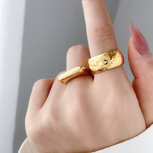Detail of 18K gold-plated rings showing hammered texture and smooth arc surface
