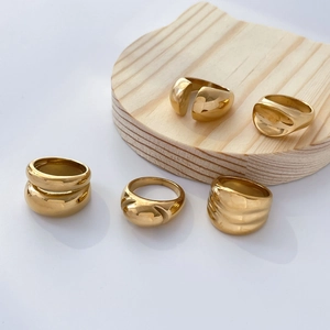 Polished 18K gold plated stainless steel chunky domed and wavy rings on wooden stands