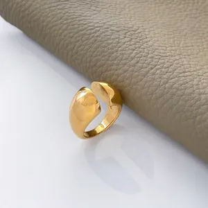 Macro view of wide 18K gold plated stainless steel ring on gray leather background