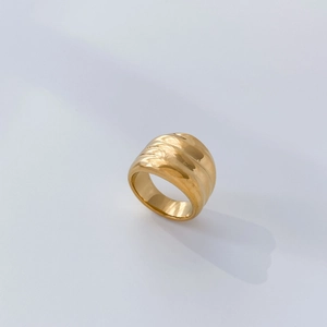 Macro detail of wide 18K gold plated ring featuring creative wavy textured grooves
