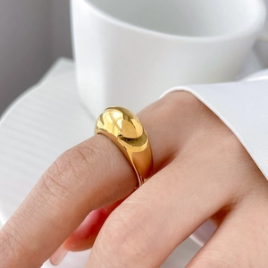 Detail of 18K gold plated concave curved ring on hand with minimalist aesthetic