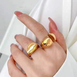 Close-up of minimalist gold plated chunky ring and double sphere open ring on a hand