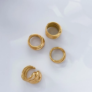 Detailed view of multi-layered 18K gold plated titanium steel rings with spiral curves