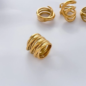 Close-up of multilayer gold-plated ring showing intertwined curved lines and high gloss