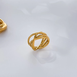 Macro detail of multilayered 18K gold-plated twisted rings with an abstract design
