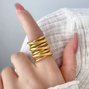 Macro detail of multi-layer layered crisscross gold band ring on a model's hand