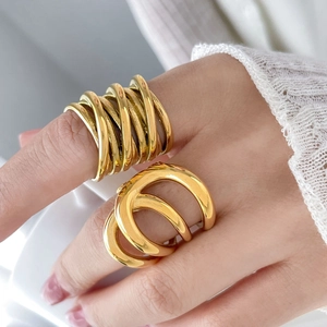 Macro detail of multi-layer crisscross gold-plated titanium steel rings with mirror finish