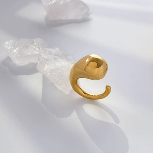 Detailed view of polished golden fluid teardrop sculpture ring with clear crystals
