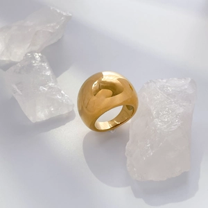 Macro detail of high-polished gold wide-band ring with a smooth dome arch design