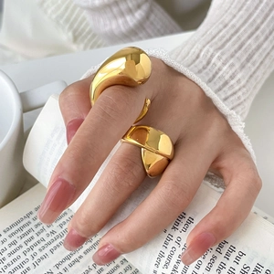 Close-up of chunky gold fluid rings worn by a model in an elegant French style setting