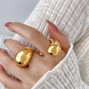Macro detail of high-polish gold dome ring with organic hollow water drop shapes