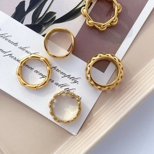 Gros plan d'un ensemble de bagues plaquées or 18 carats aux textures bambou et tressée