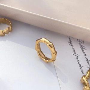 Vue détaillée d'une bague style bambou doré présentant une structure articulée unique