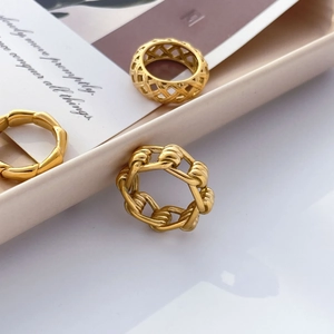 Détail de trois bagues empilables en titane plaqué or 18 carats avec textures tressées