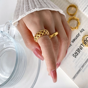 Bagues en acier titane plaqué or 18 carats avec motifs tissés et évidés portées par modèle