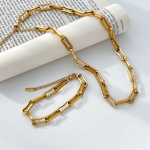 Detail of gold-plated wavy paperclip chain jewelry set with K18 engraving on the tag