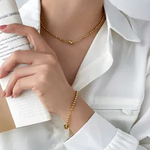 Elegant gold bead necklace and bracelet set shown on model in minimalist French style