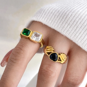 Gold-plated ring set with emerald cut green stone and black heart-shaped zircon gemstone