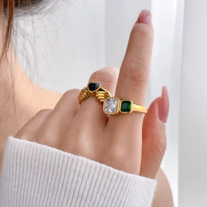 Macro detail of French vintage gold rings with emerald and black oval gemstones
