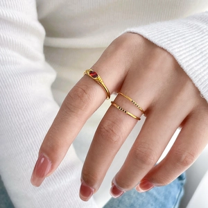 Detail of vintage gold rings featuring an oval red stone and delicate black zircon stones
