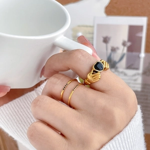 Detailed view of gold Claddagh ring set with black heart gem and micro-pave crystals