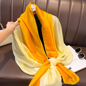 Detail of gradient orange satin silk scarf with glossy texture draped on a display