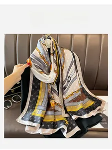 Close-up of elegant silk scarf with golden chain patterns and luxurious satin texture