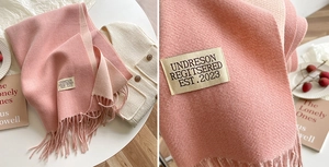 Detail of pink double-sided cashmere-like scarf with fringe and vintage woven label