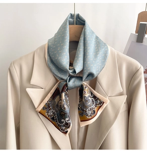 Detail of light blue paisley silk scarf draped over a beige blazer for styling