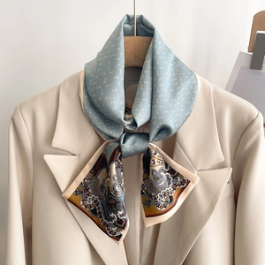 Detail of blue paisley silk scarf styled on a beige blazer for a professional look